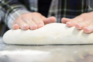 Student Samantha Milota rolls out bread dough during a FS 551: Fermented Food and Beverage class taught by Nick Smith, associate outreach specialist in the Department of Food Science at the University of Wisconsin-Madison, on April 25, 2018. The students in the course are helping to test the strains for suitability in bread baking, and are partnering with Clasen's Bakery in Middleton, Wisconsin to do so. (Photo by Bryce Richter / UW-Madison)