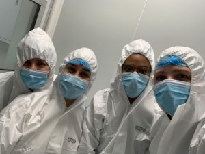 Four scientists in full PPE pose for photo while working in vaccine production facility at Afrigen.